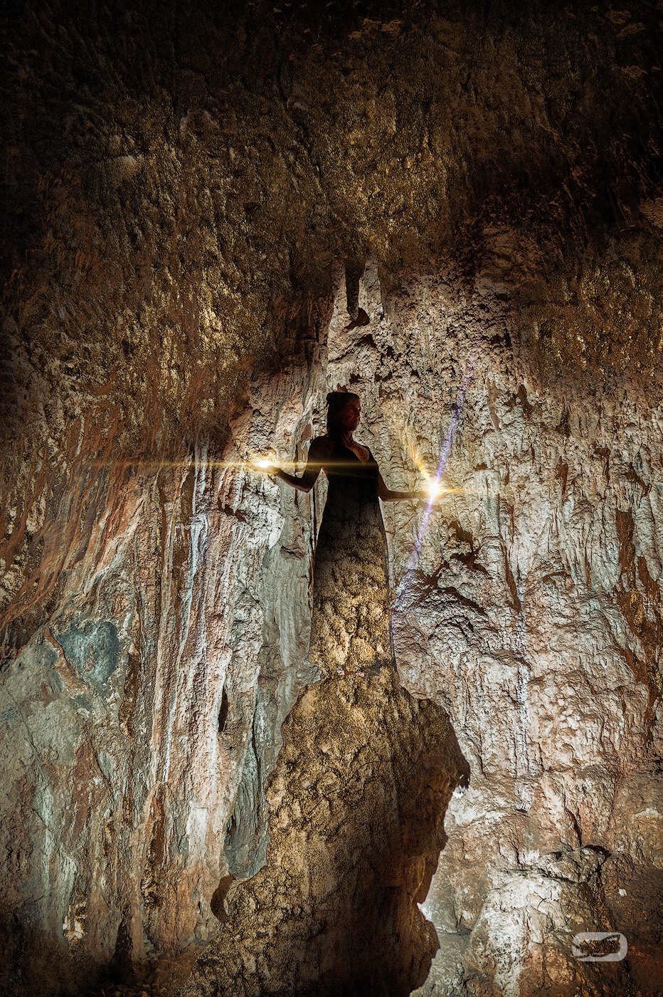 spirituelles coaching und zen meditation für emotionale heilung und embodiment Eine Person steht in einer zerklüfteten Höhle, die von einem Lichtstrahl beleuchtet wird, der eine dramatische Silhouette vor den strukturierten Felswänden erzeugt - eine Atmosphäre, die an Zazen-Meditation inmitten von zerklüfteten Kanten und erdigen Tönen erinnert.